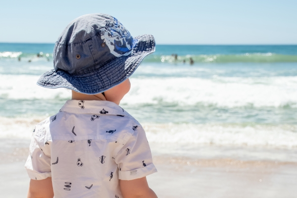 호주 해변에서 모자를 쓰고 있는 어린이